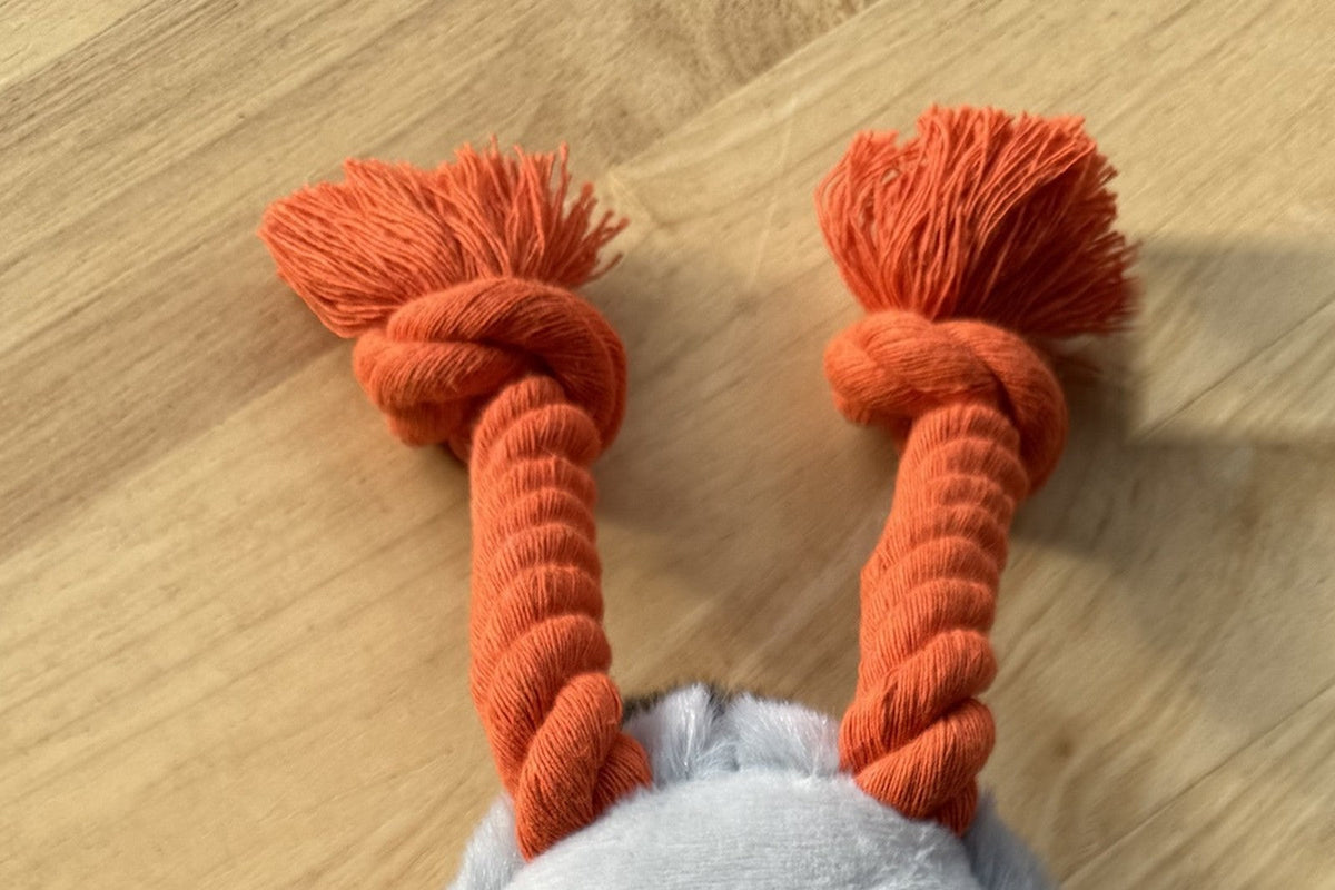 De twee oranje gevlochten touwpootjes van dichtbij